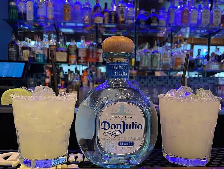 A bottle of tequila and two margaritas